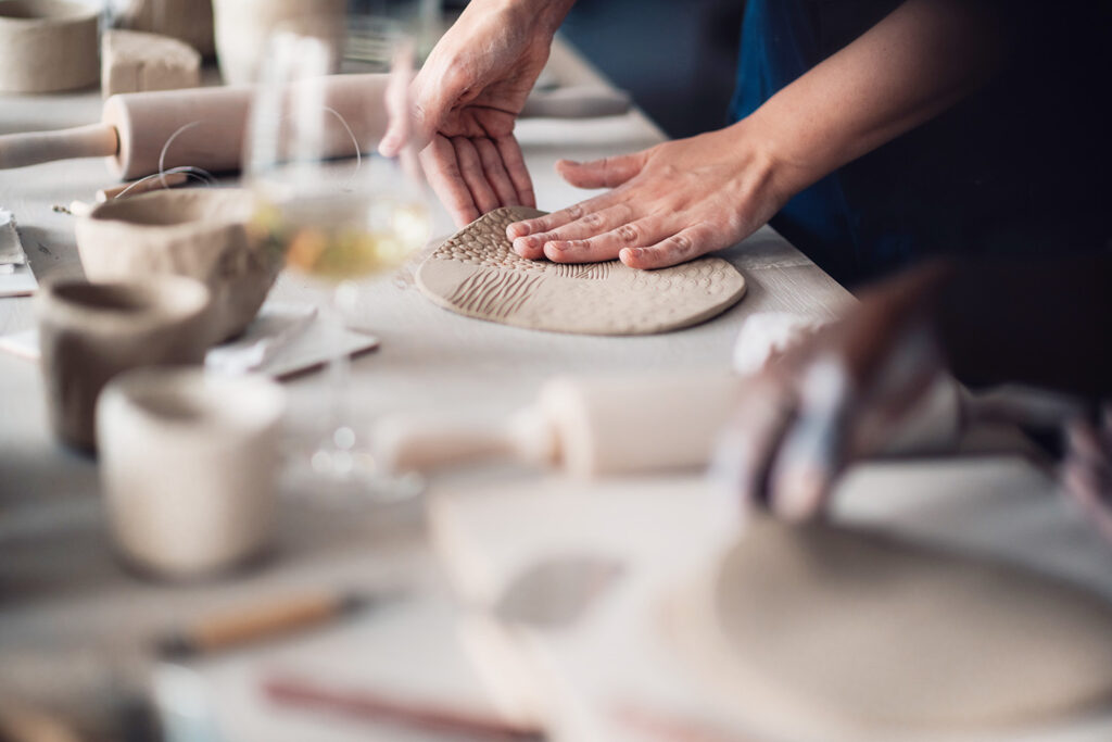Hände formen eine Tonplatte im Workshop – Atelier Tonga München.