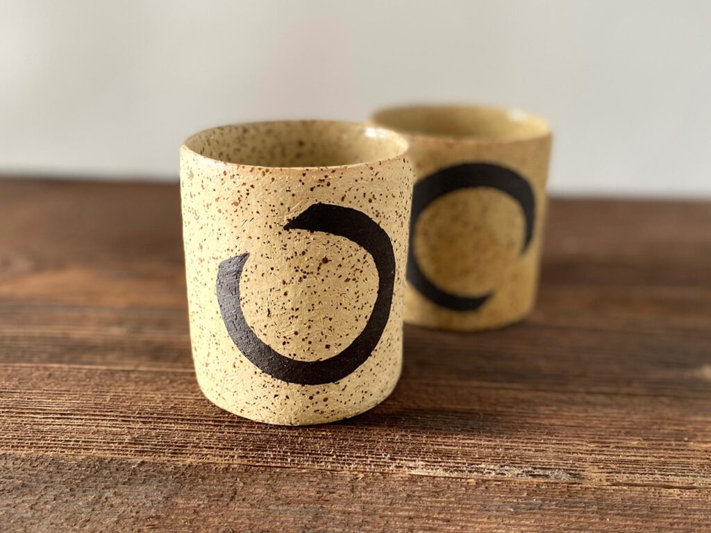 Zwei gelb gesprenkelte Keramikbecher mit schwarzem Dekor – Atelier Tonga.
