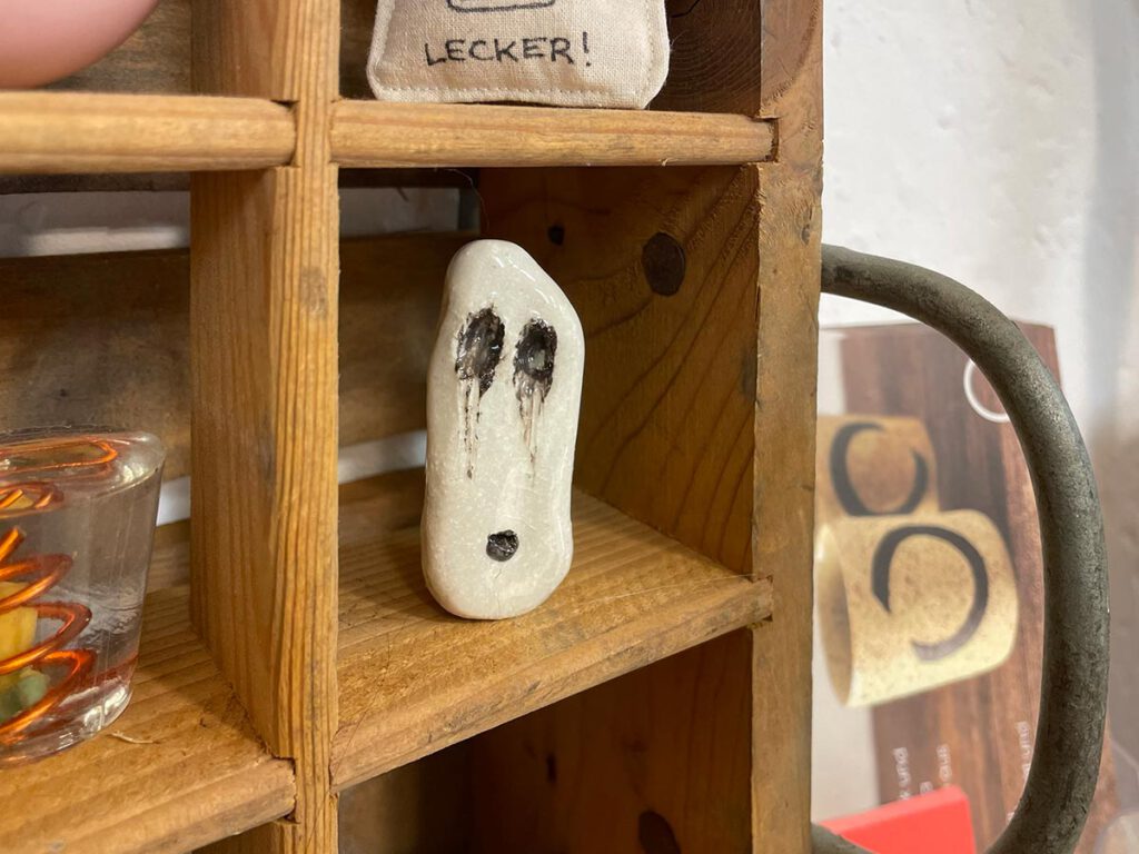 Holzregal mit Keramikmaske – Atelier Tonga.