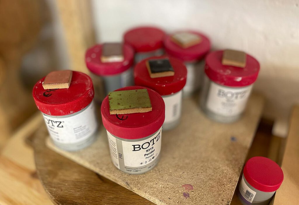 Keramikglasuren mit roten Deckeln von BOTZ im Atelier Tonga.